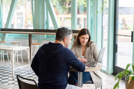 A man and woman, discussing the importance of sales enablement automation in the current market landscape.