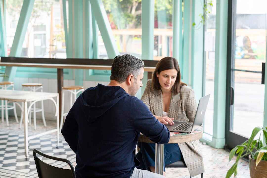 A man and woman, discussing the importance of sales enablement automation in the current market landscape.